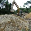 The foreground pile is the light grey pay gravel layer that the excavator got into. The brown pile in the background is about 6 feet of topsoil/overburden that was removed to get down to the pay layer.